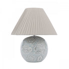 A floral globe lamp with a soft glow and a white lampshade.