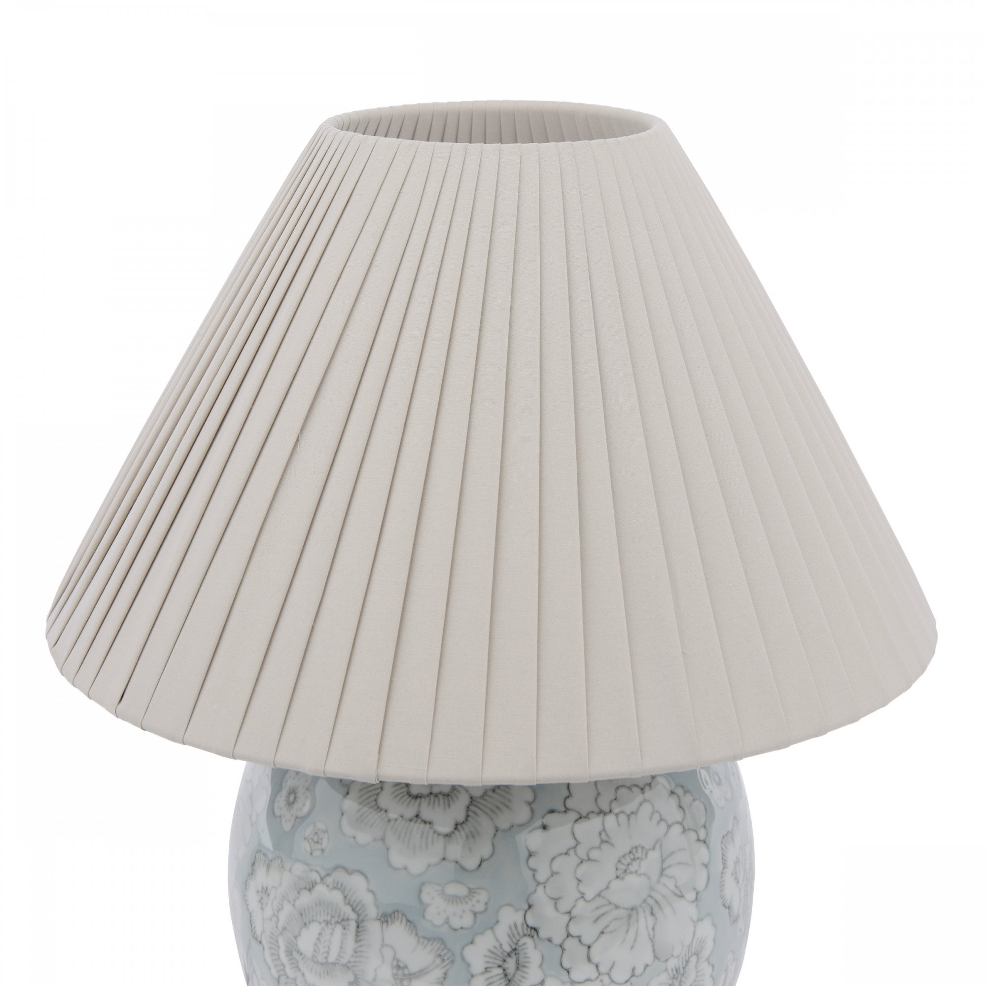 A close-up of the pleated fabric lampshade atop a floral globe lamp.
