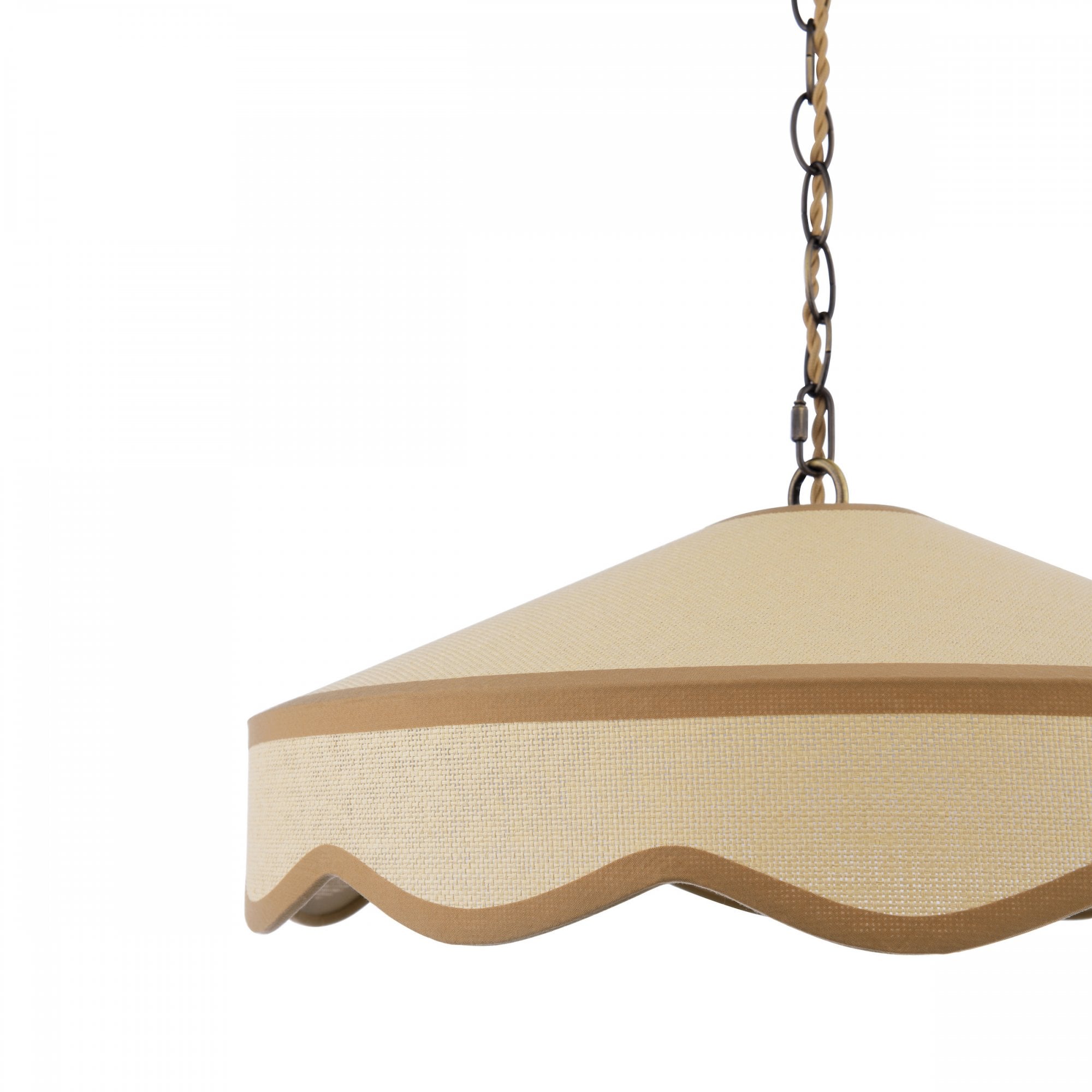 A close-up view of the cream-colored shade and wavy trim of a hanging ceiling light.