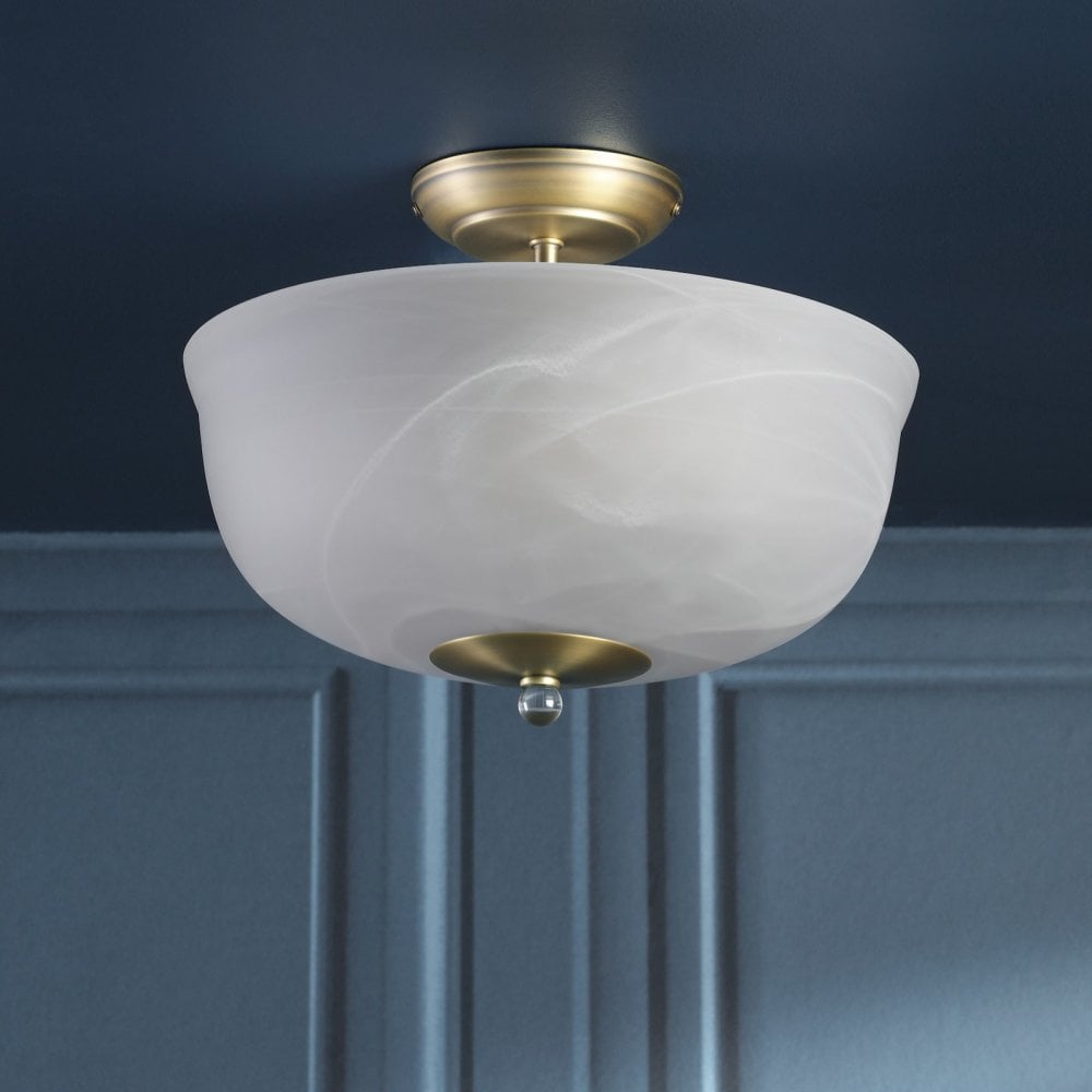 A semi-flush ceiling light with a brass base and a white marbled glass shade, unlit.