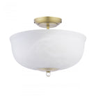 A semi-flush ceiling light with a brass base and a white marbled glass shade, unlit.