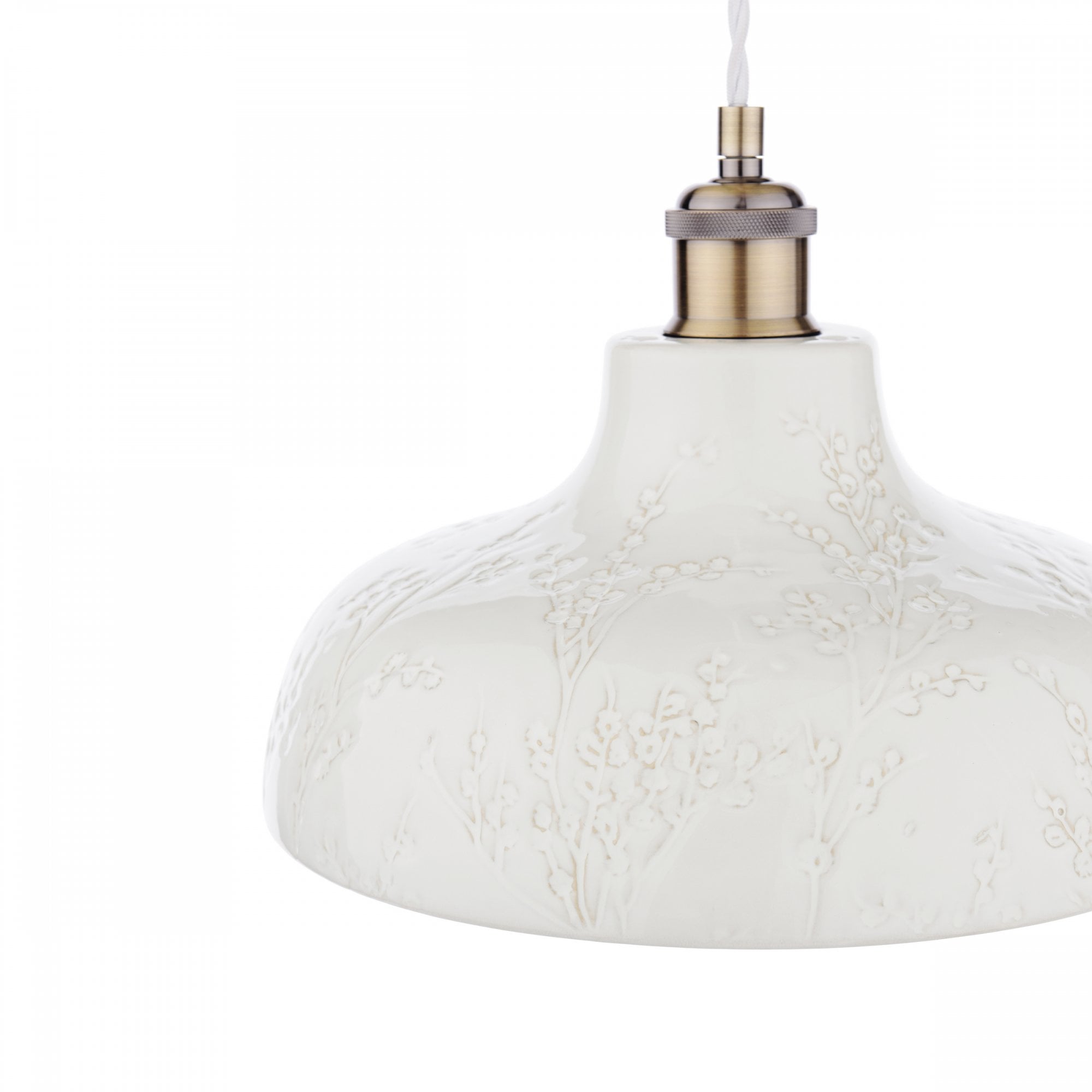 Close-up of the white textured shade and brass fixture of a pendant light.