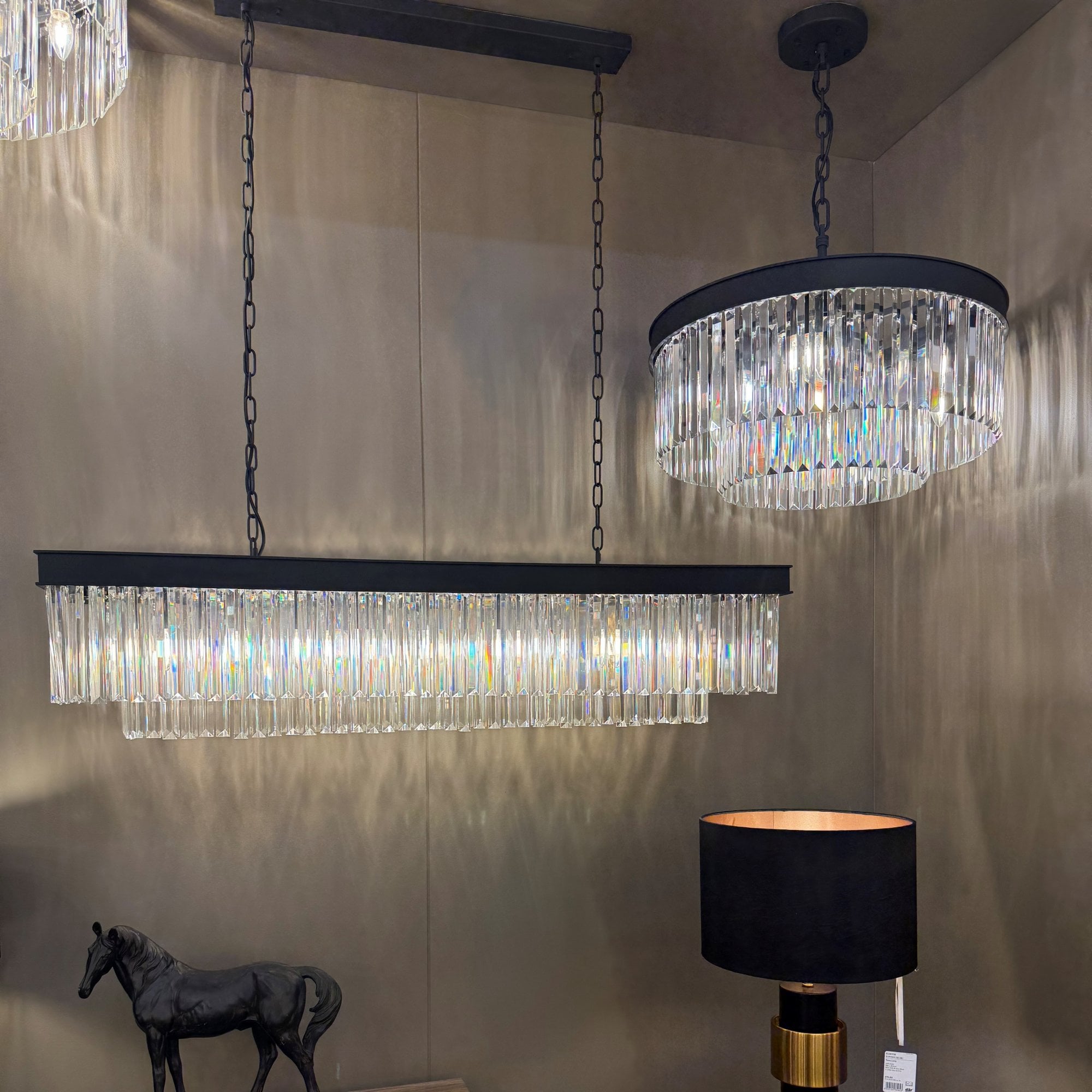 A rectangular chandelier and a round chandelier with black frames and crystal rods.
