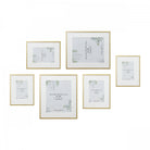 A collection of six gold picture frames with white matting, arranged on a white background.
