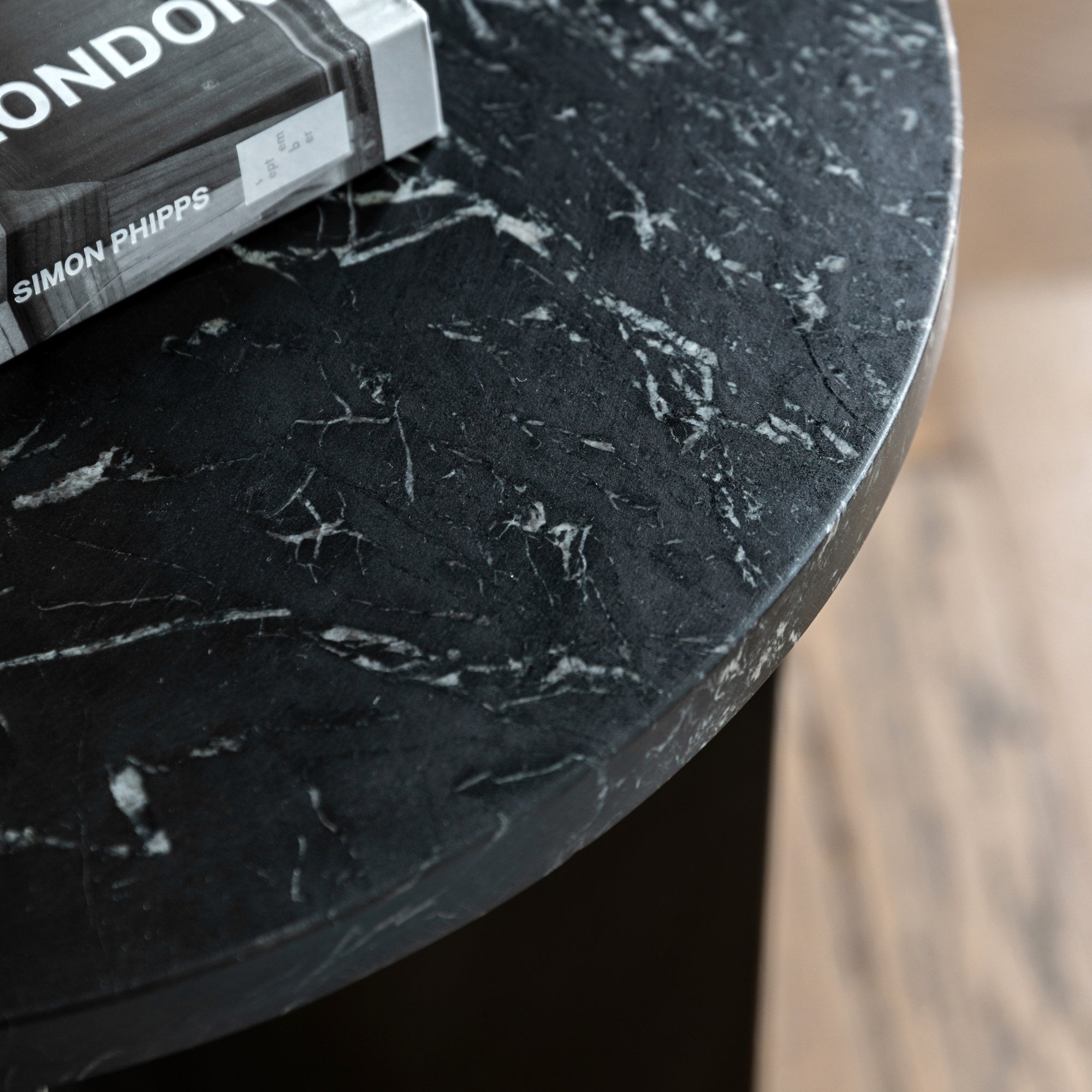 Close-up of the black marble tabletop with white veining and a book.
