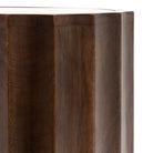 A close-up showing the vertical fluted design of the dark wood side table.