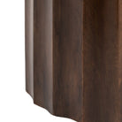 A detailed shot of the fluted texture and grain of the dark wood side table.