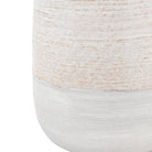 Close-up of the textured base of a light-colored ceramic vase with a two-tone effect.