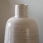 Close-up of the beige glazed vase with a textured matte base.
