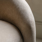 Detailed close-up of the beige sofa's textured fabric and stitching on an armrest.