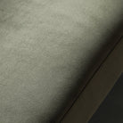 Close-up of the soft, textured sage green velvet fabric of the sofa.