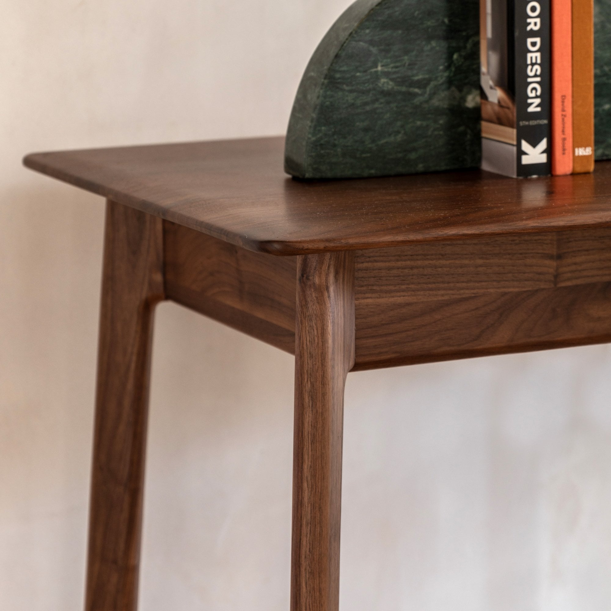 Close-up of the smooth, dark wood surface of the desk with subtle grain details.