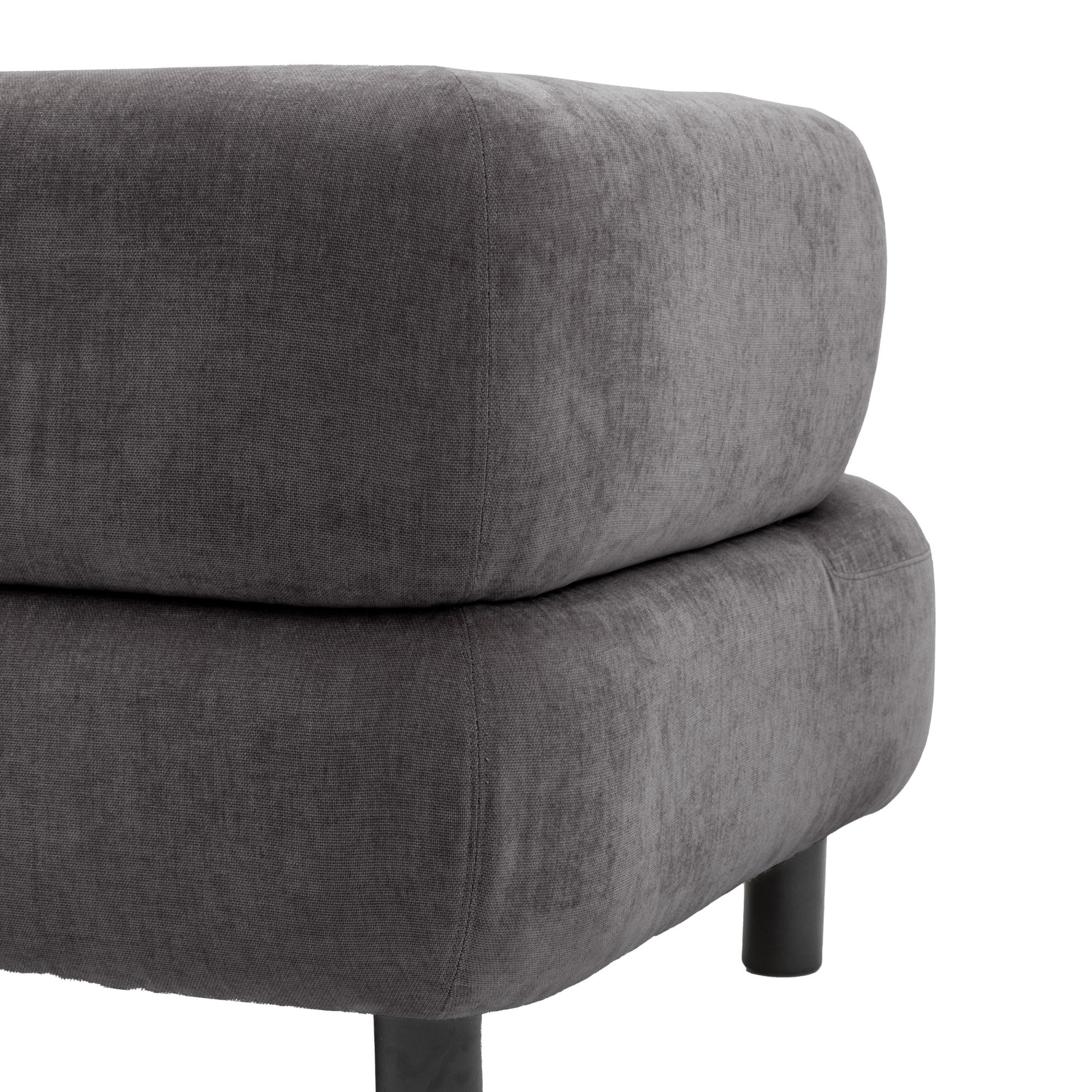 A close-up of the grey sofa's textured fabric on its cushion and base.