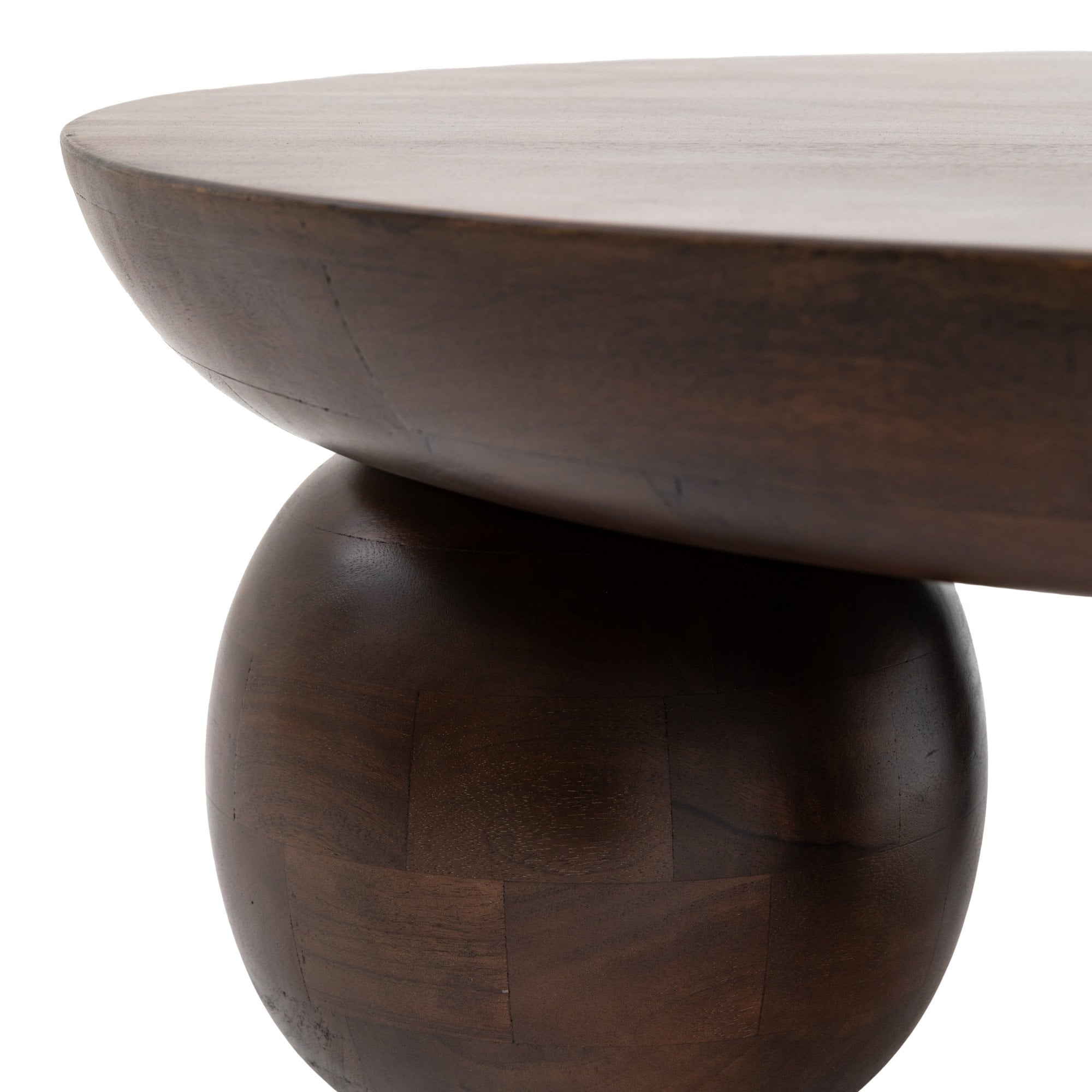 Close-up view of the smooth dark wood coffee table and its spherical leg design.