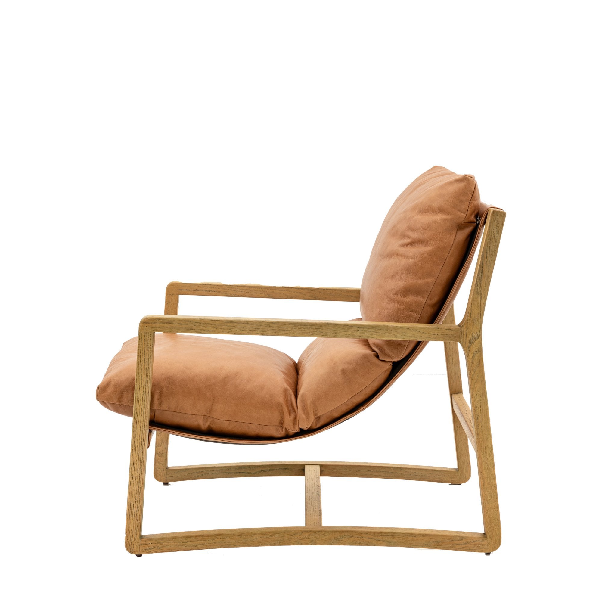 Side profile of a tan leather and light wood armchair.