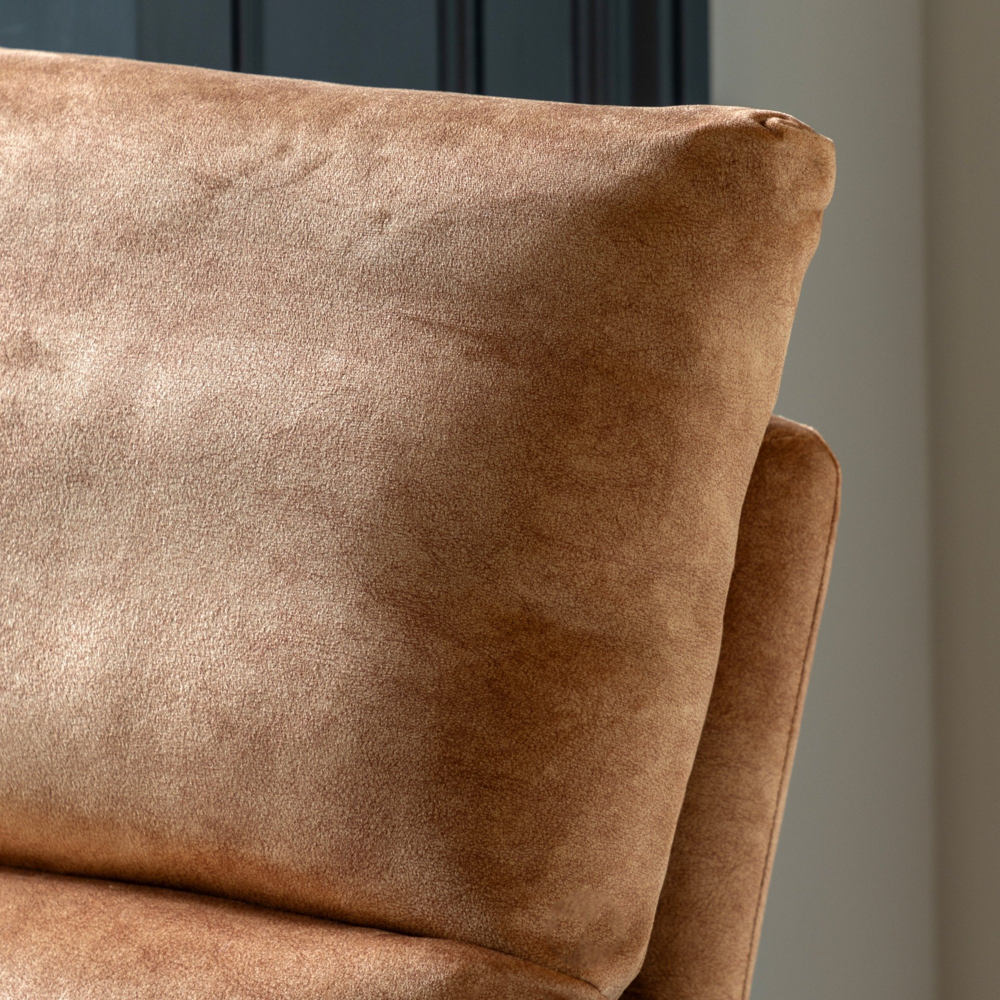 Detail shot of the plush brown fabric of a lounge chair's back cushion.