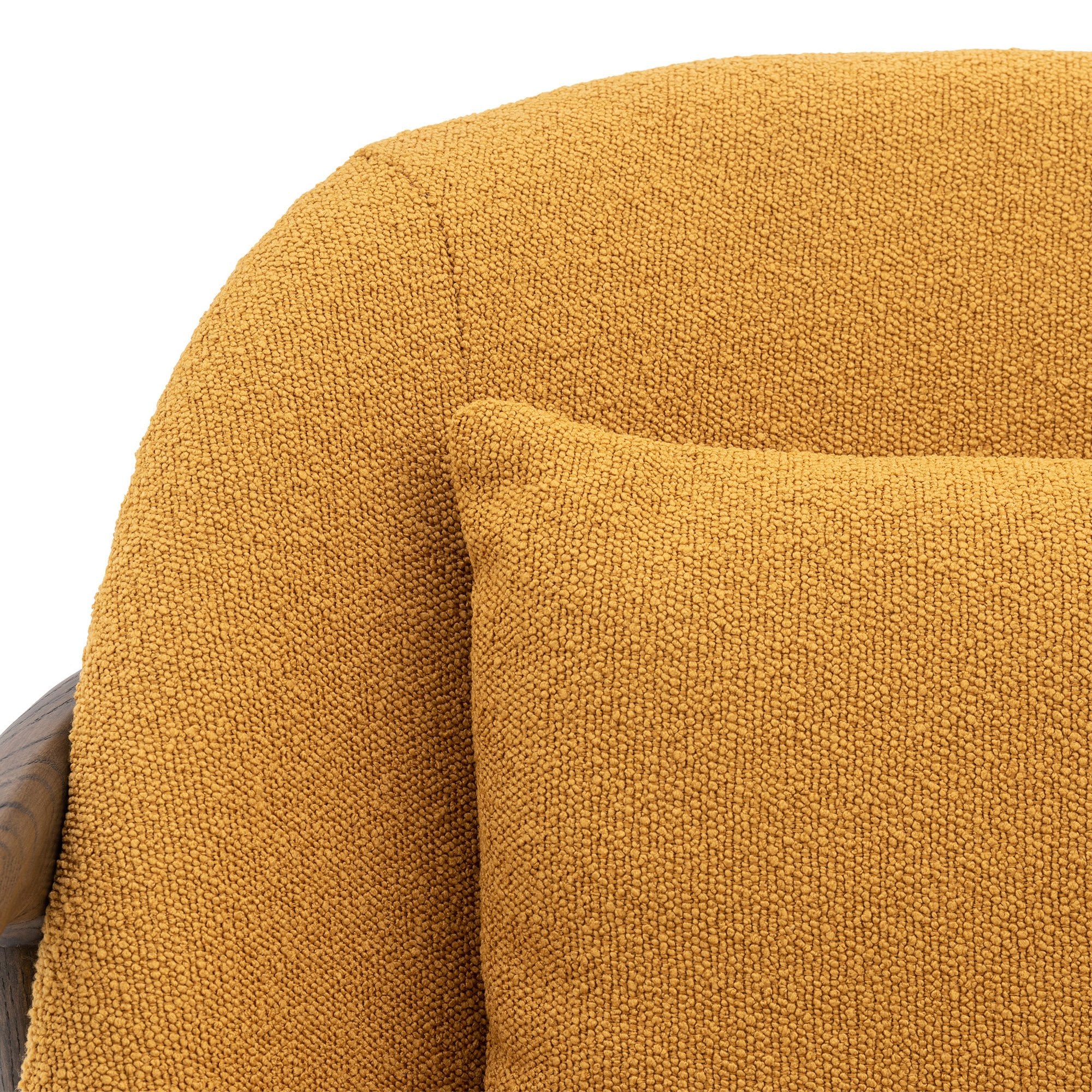 Close-up of the textured mustard yellow fabric of an accent chair's backrest and cushion.