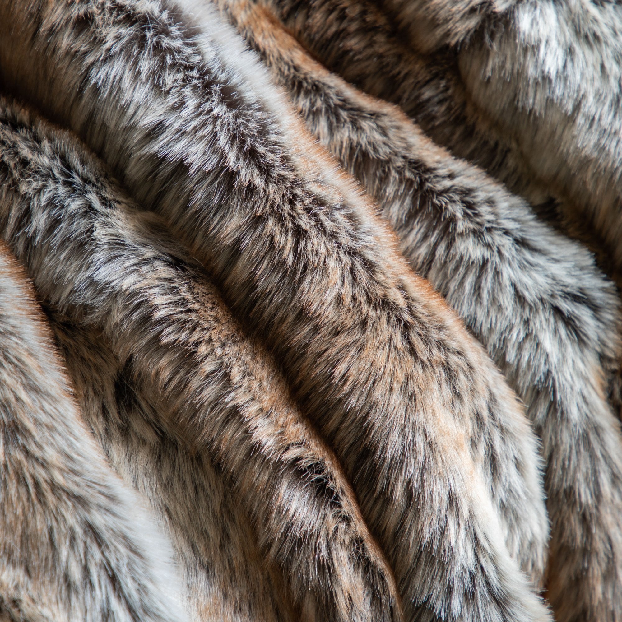 A detailed close-up of the faux fur throw, highlighting the soft, varied textures and colors.