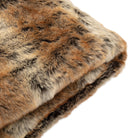 A close-up, angled view of the folded faux fur throw, highlighting its luxurious texture and color.