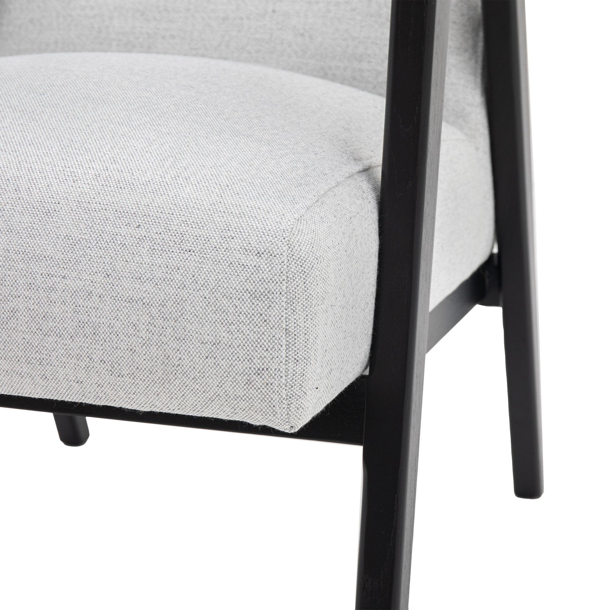 Close-up of the light grey upholstered seat cushion and dark wooden leg of the armchair.