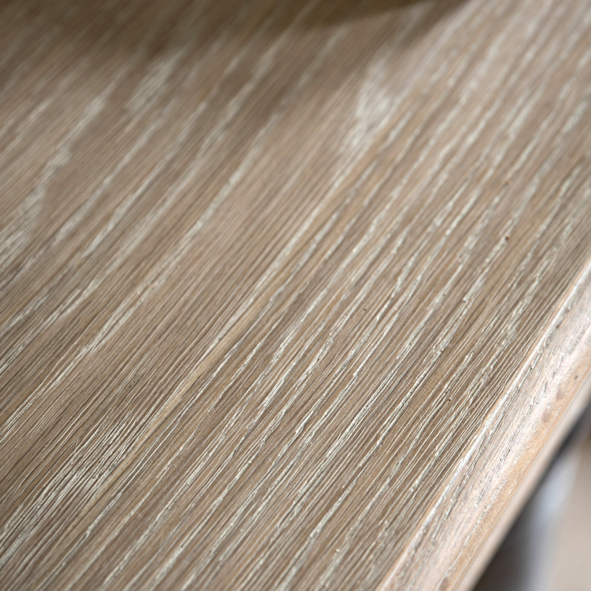 Close-up of the light wood grain on the console table's surface.