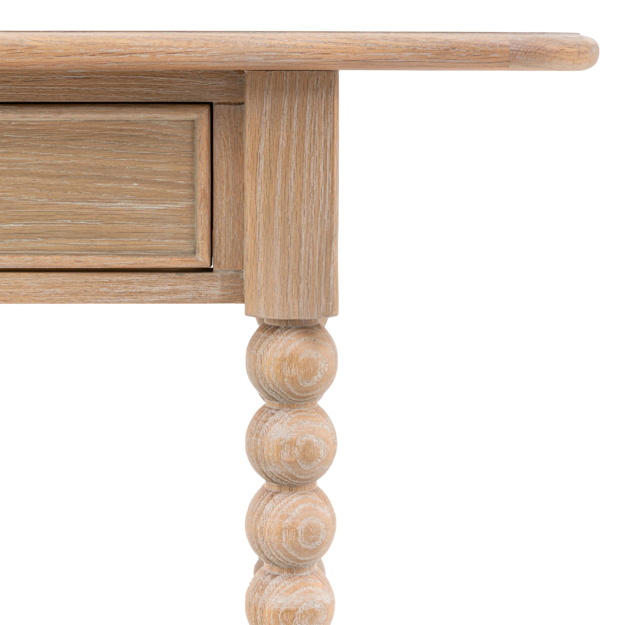 Close-up of a drawer and a bobbin leg on the light wood console table.