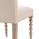 Close-up of the rounded front legs and upholstered seat of a dining chair.