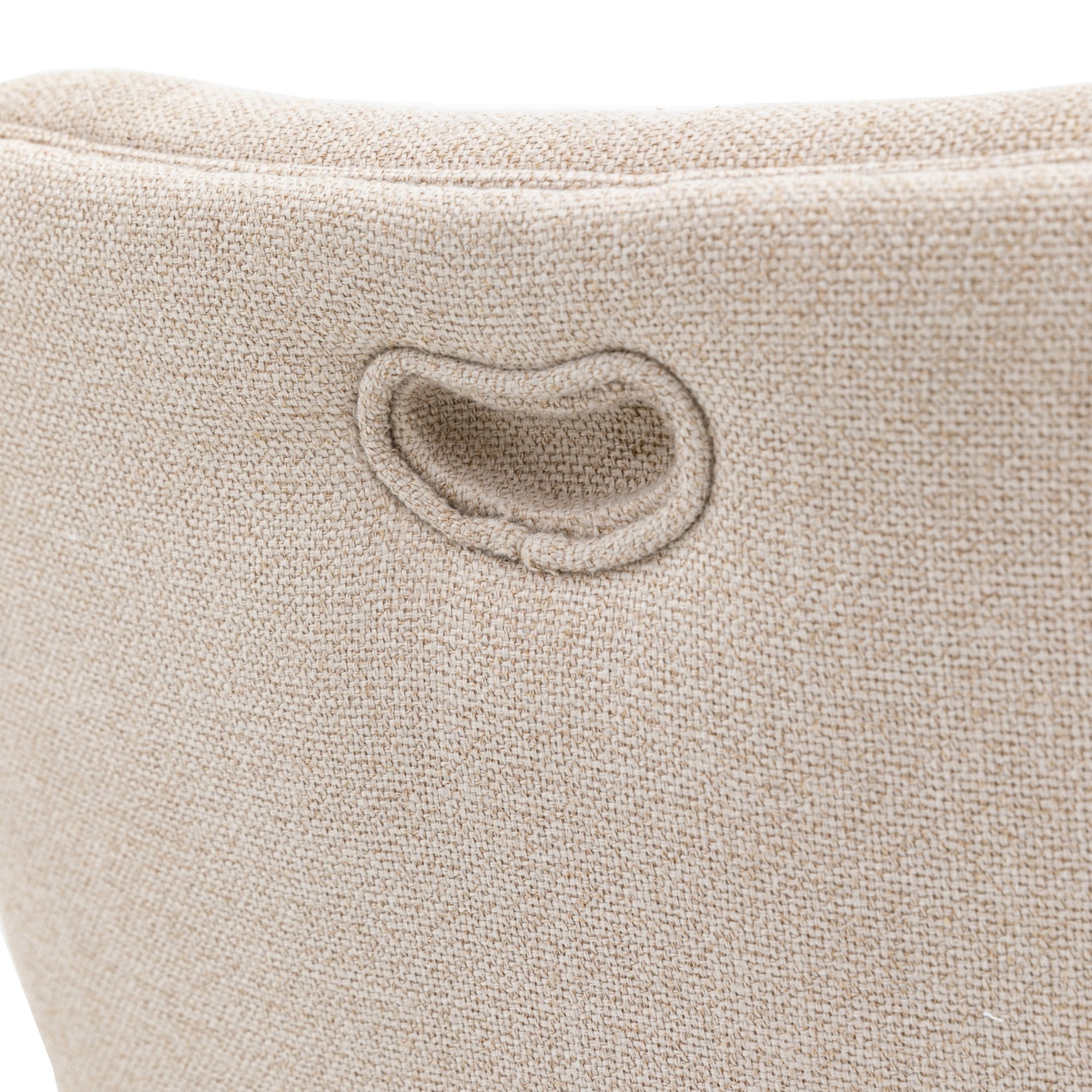 Close-up of the small, indented handle on the back of an upholstered dining chair.