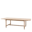 A light wood dining table with bobbin legs on a white background, viewed from an angle.