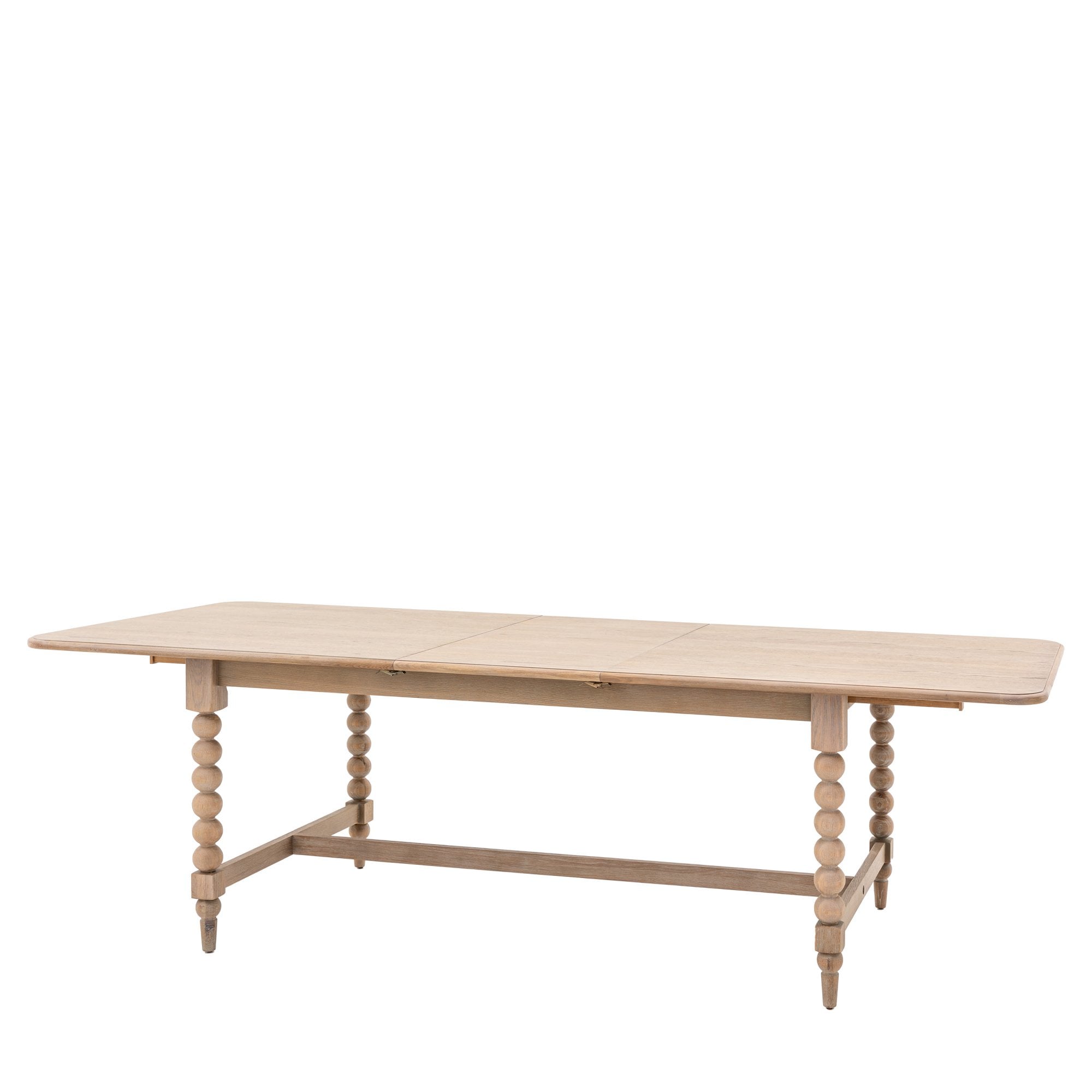 A light wood dining table with bobbin legs on a white background, viewed from an angle.