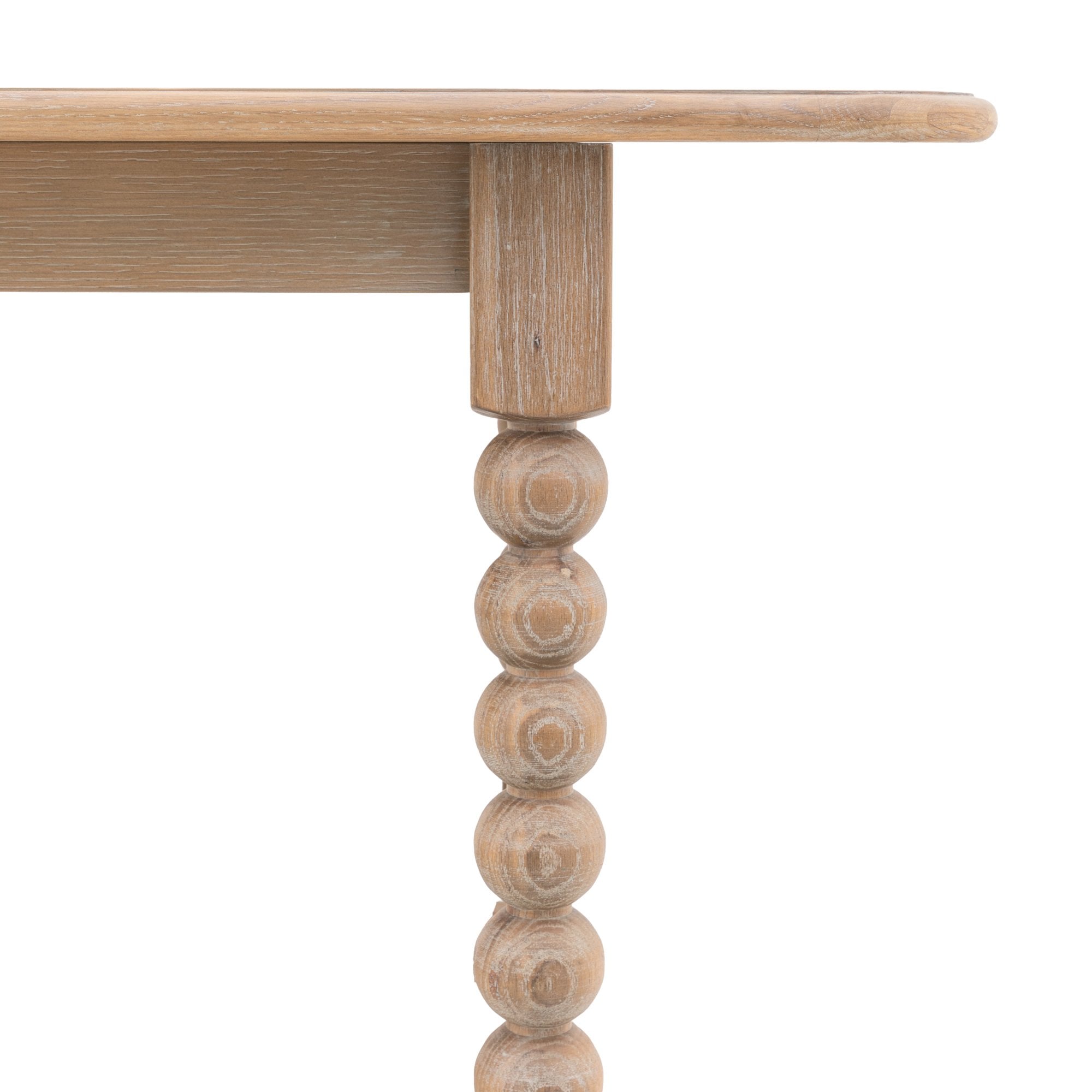 Close-up of the light wood table top and a bobbin-style leg.