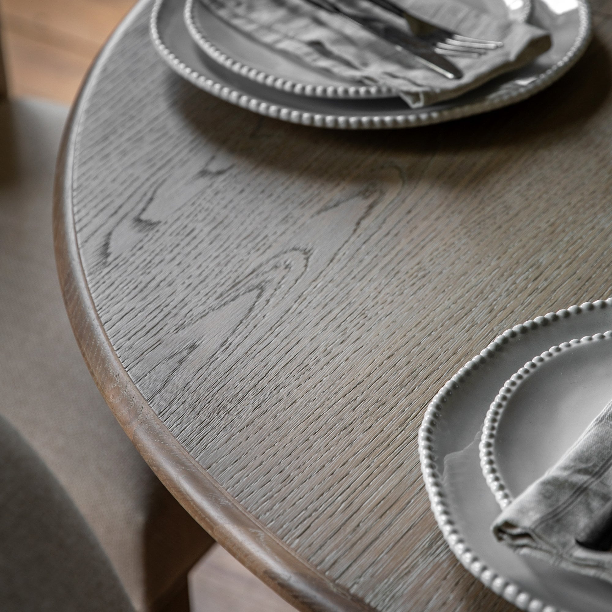 Close-up of the dining table surface, showing wood grain and place settings.