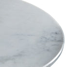 Close-up of the smooth, round white marble tabletop with gray veining.