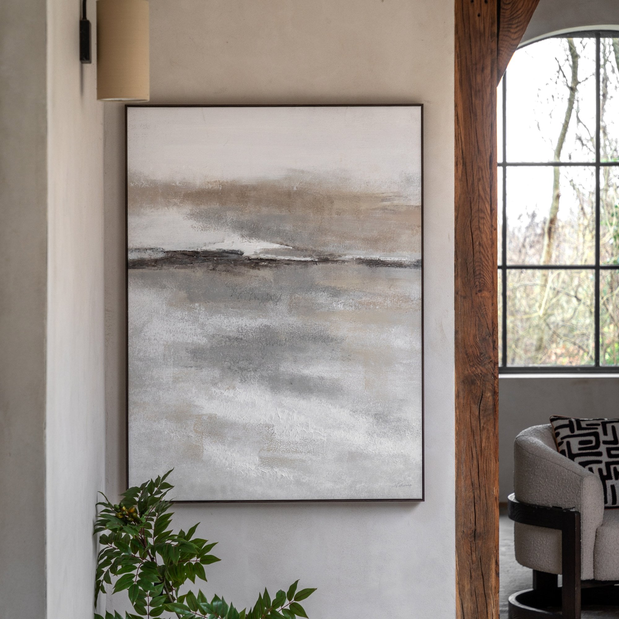 Abstract painting in neutral tones hanging on a wall in a living room.