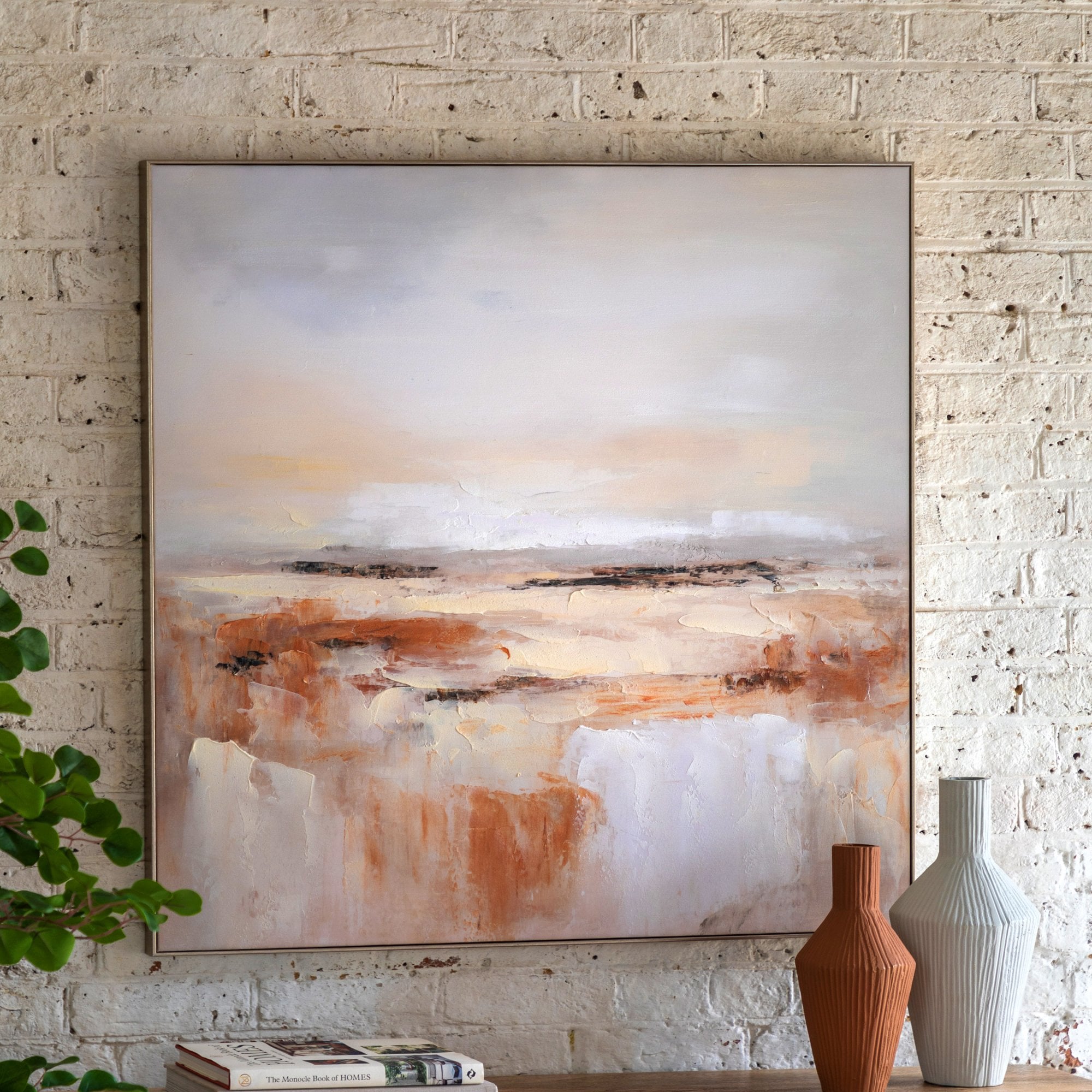 Abstract painting on a white brick wall, two white vases in the foreground.