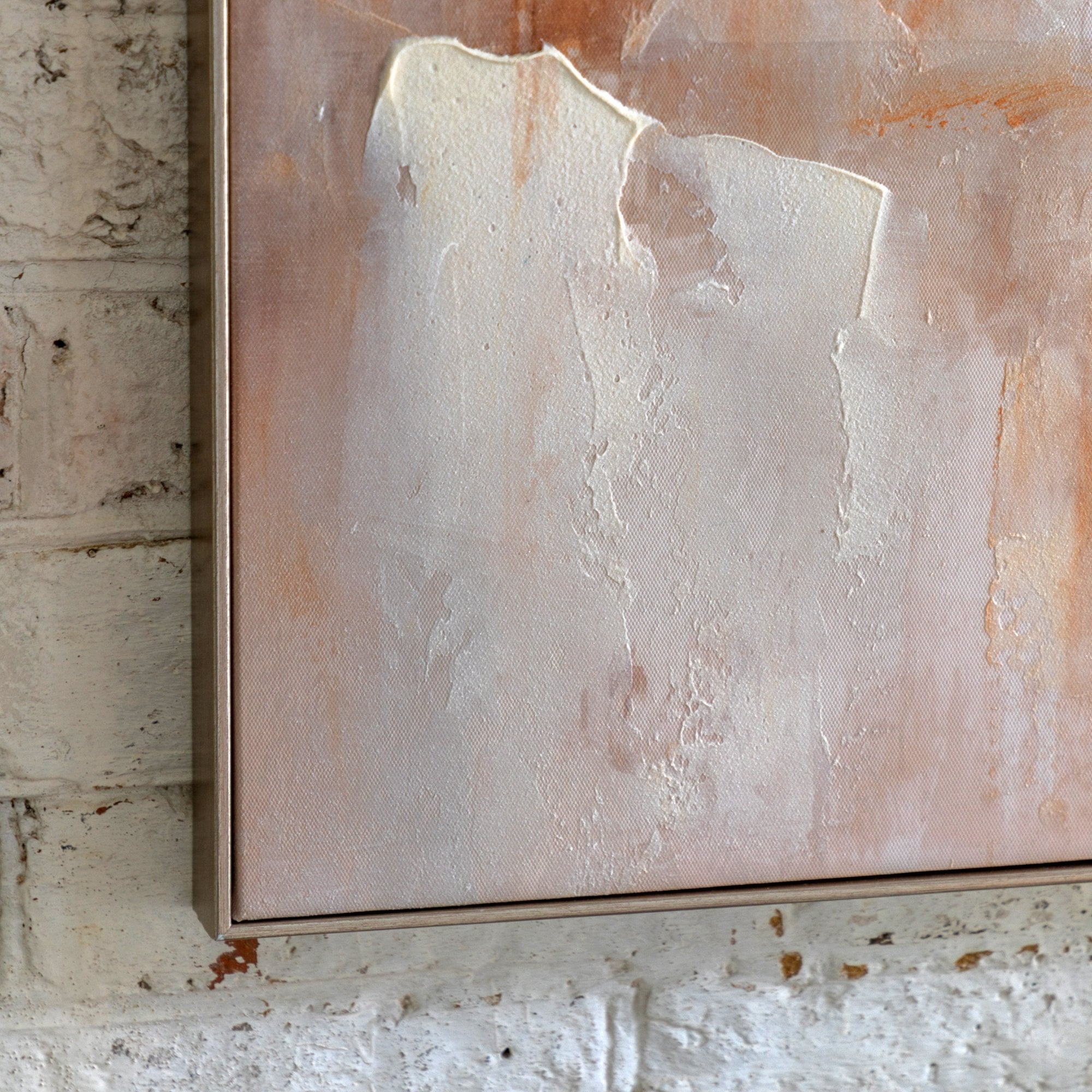 Close-up of abstract painting on a white brick wall, showing brushstrokes and texture.