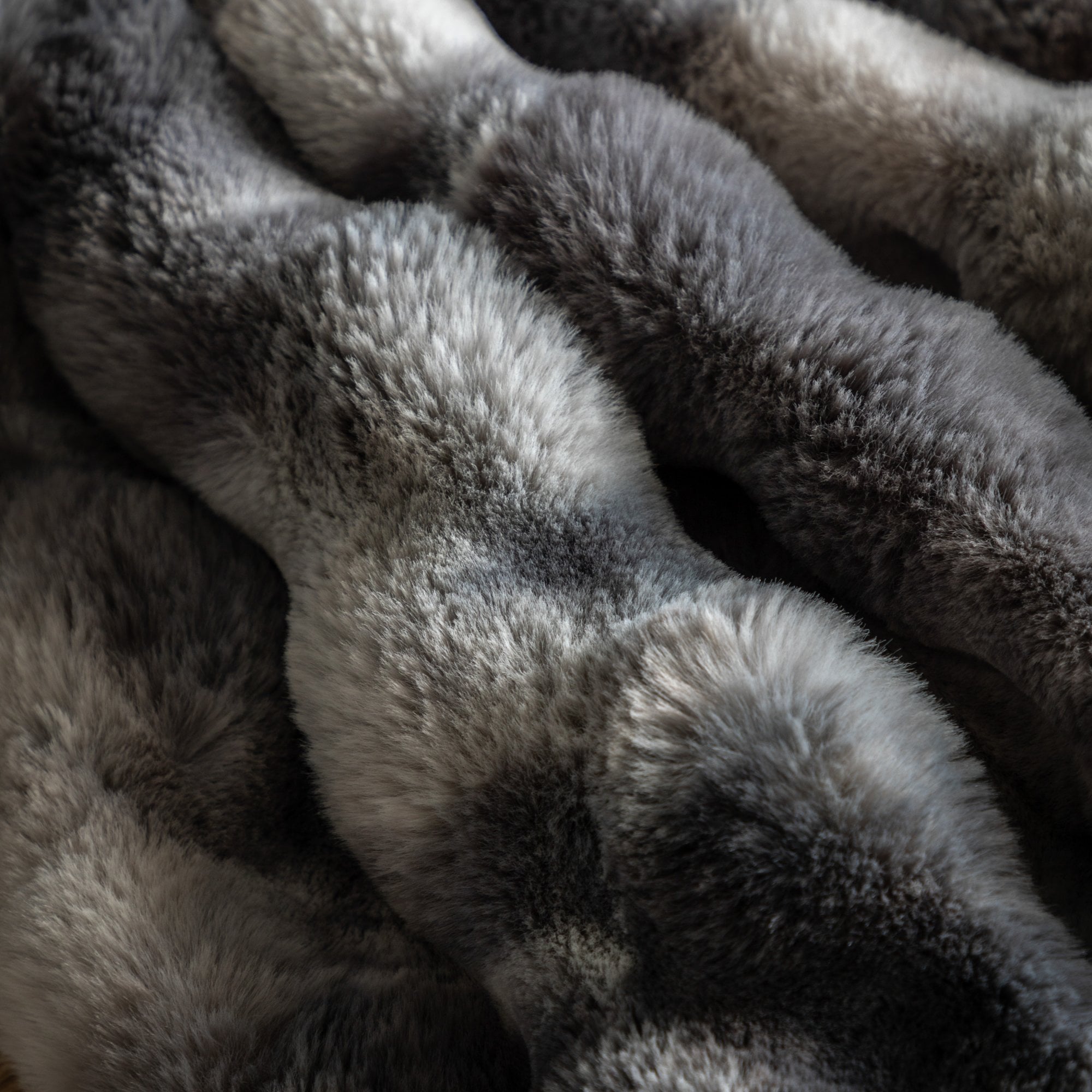 Close-up of the textured, plush gray and white faux fur blanket.