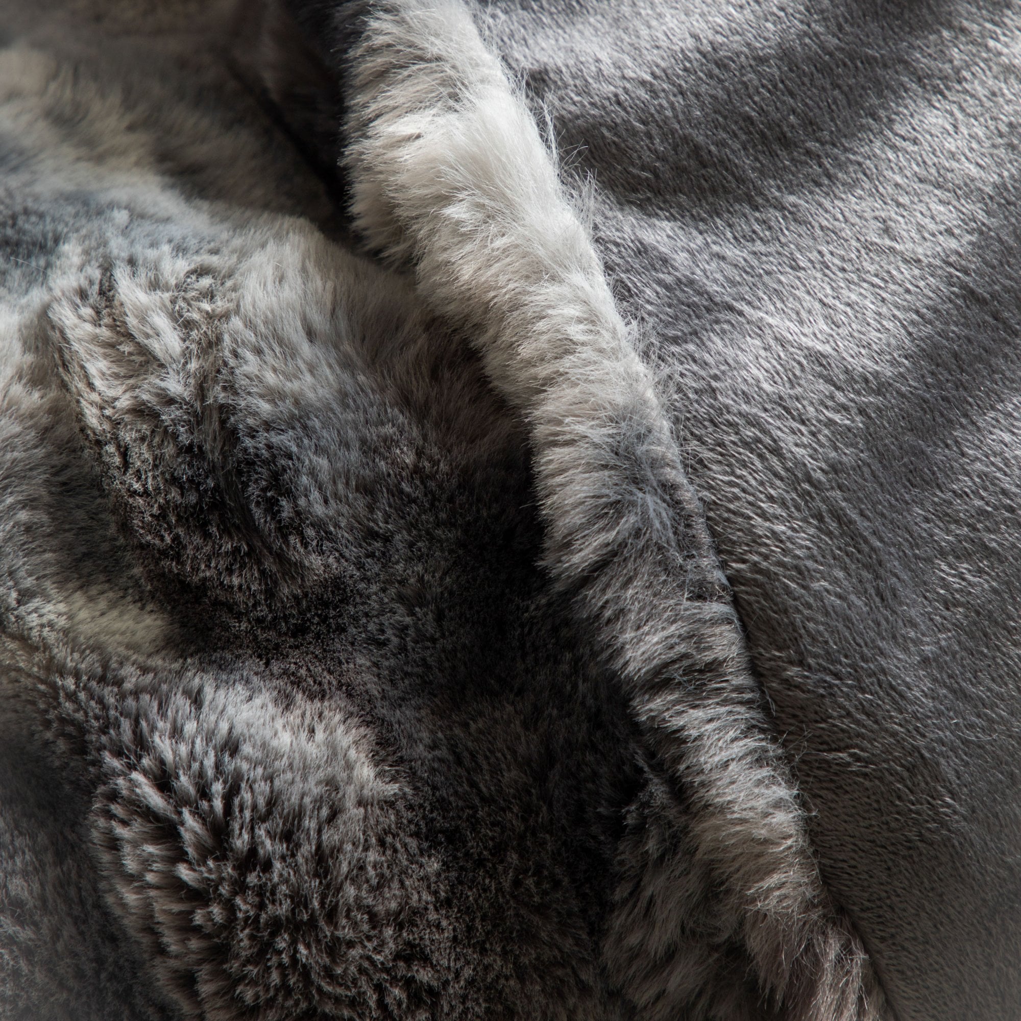Detail shot of the soft and varied gray tones within the faux fur throw.