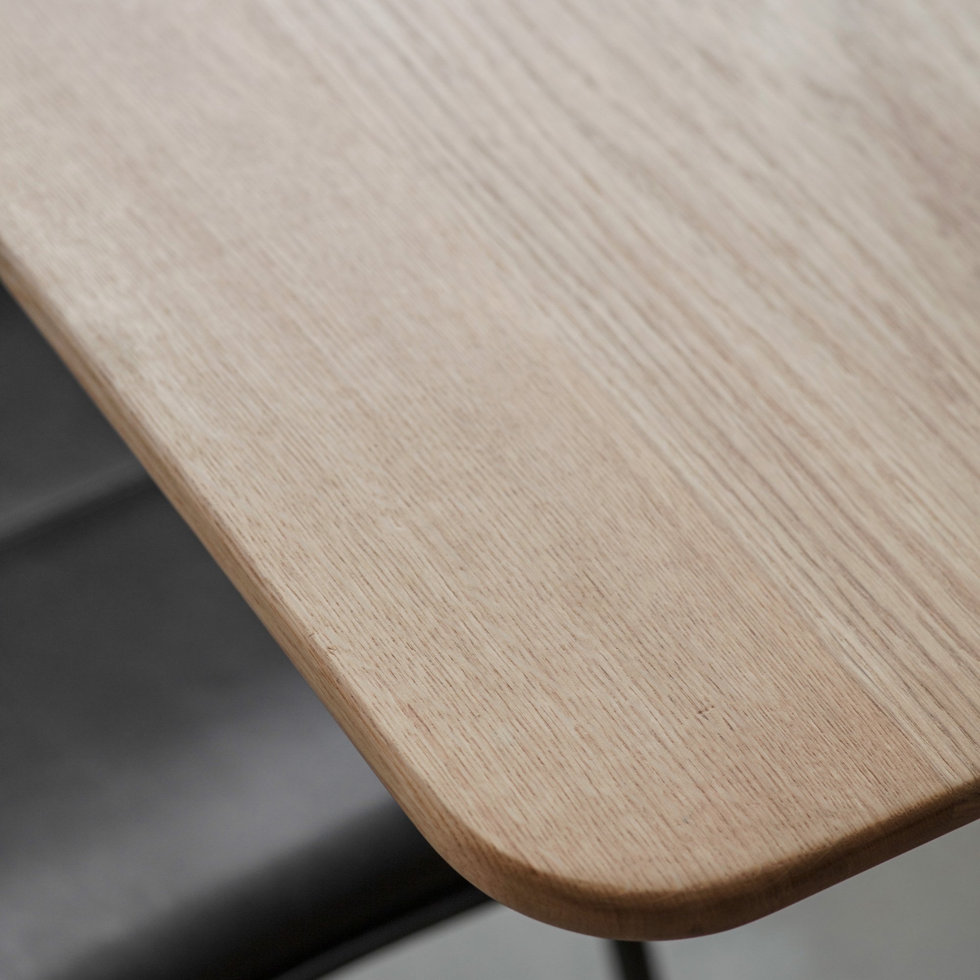 Close-up of the light wood grain on the dining table surface.