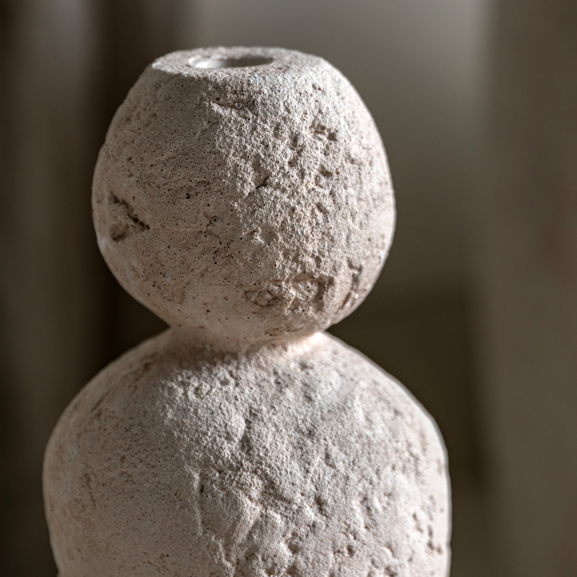 Close-up of the textured top portion of a white vase, resembling a head.