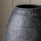 Close-up of the textured, dark gray surface of a vase.