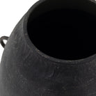 A close-up view of the top opening of a dark, textured vase.