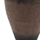 A close-up view of the textured, brown lower portion of a vase.