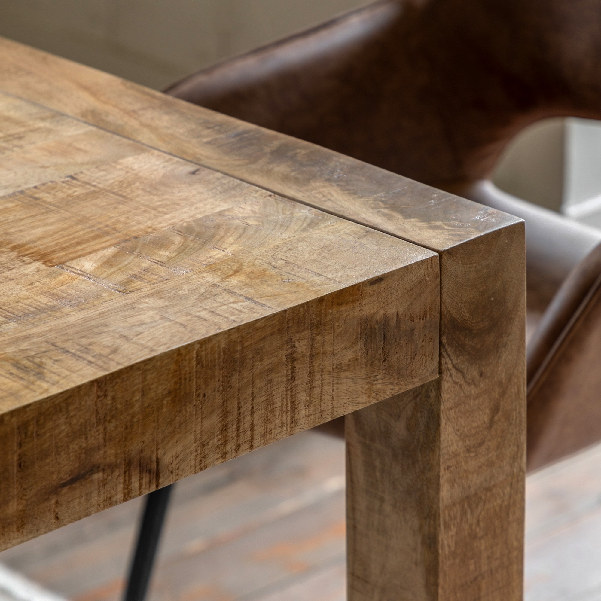 Close-up of the natural wood grain and construction of a dining table's corner.