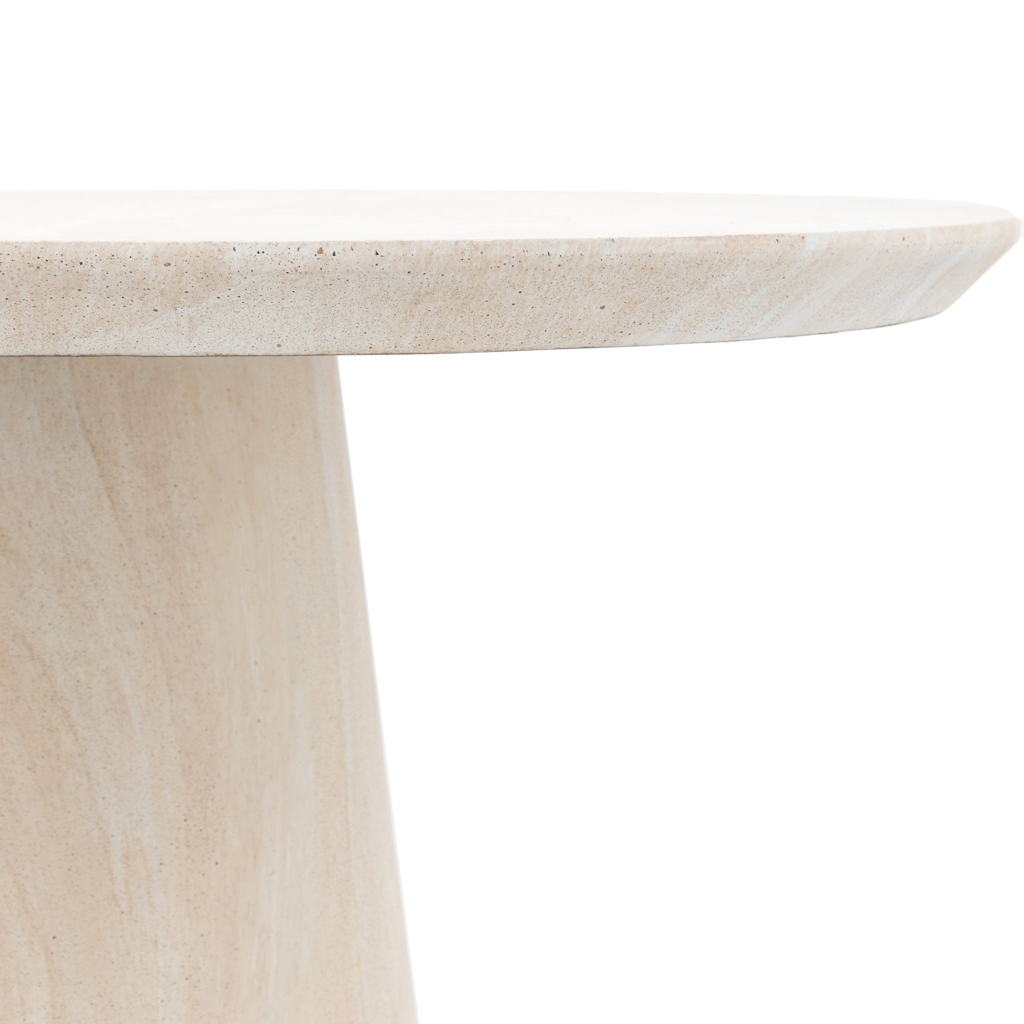 Close-up of the rounded edge of a light beige stone tabletop with a conical base.