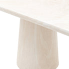 Close-up of the square corner of a light beige stone tabletop with a conical base.