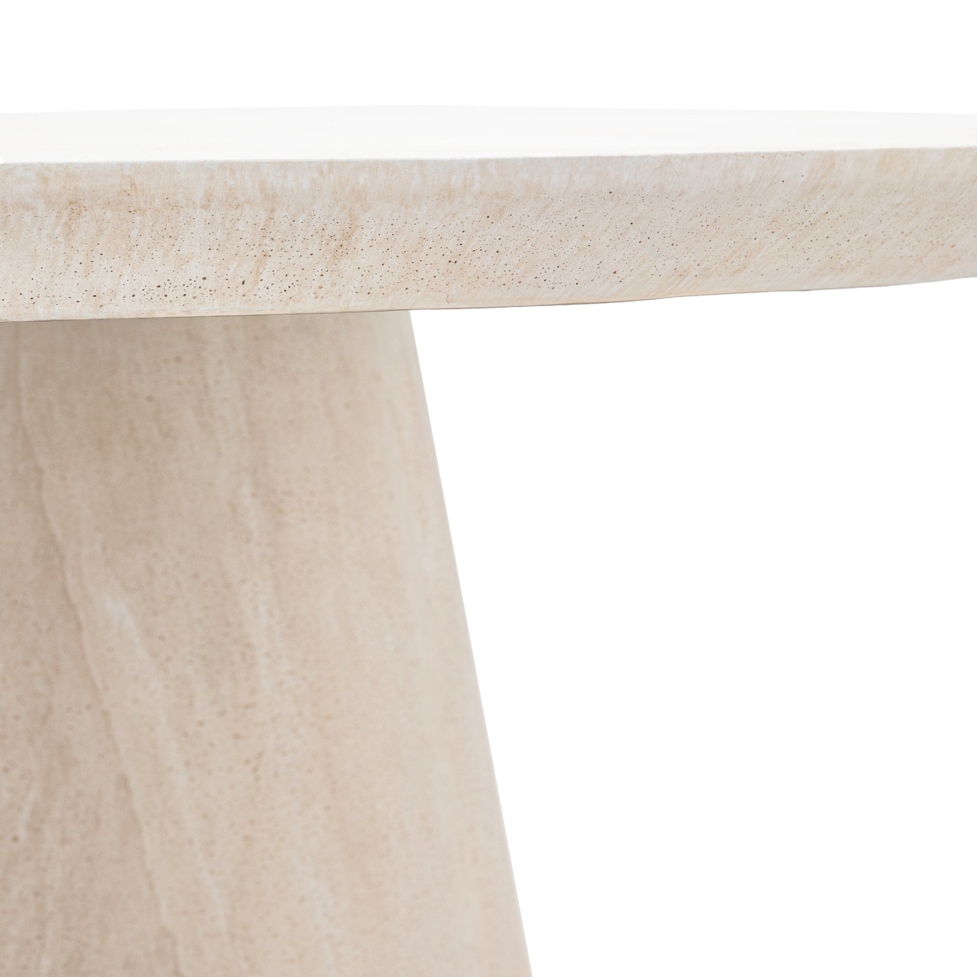 Close-up of the smooth edge and conical base of the travertine dining table.