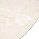 Close-up of the light-colored travertine tabletop surface with natural patterns.