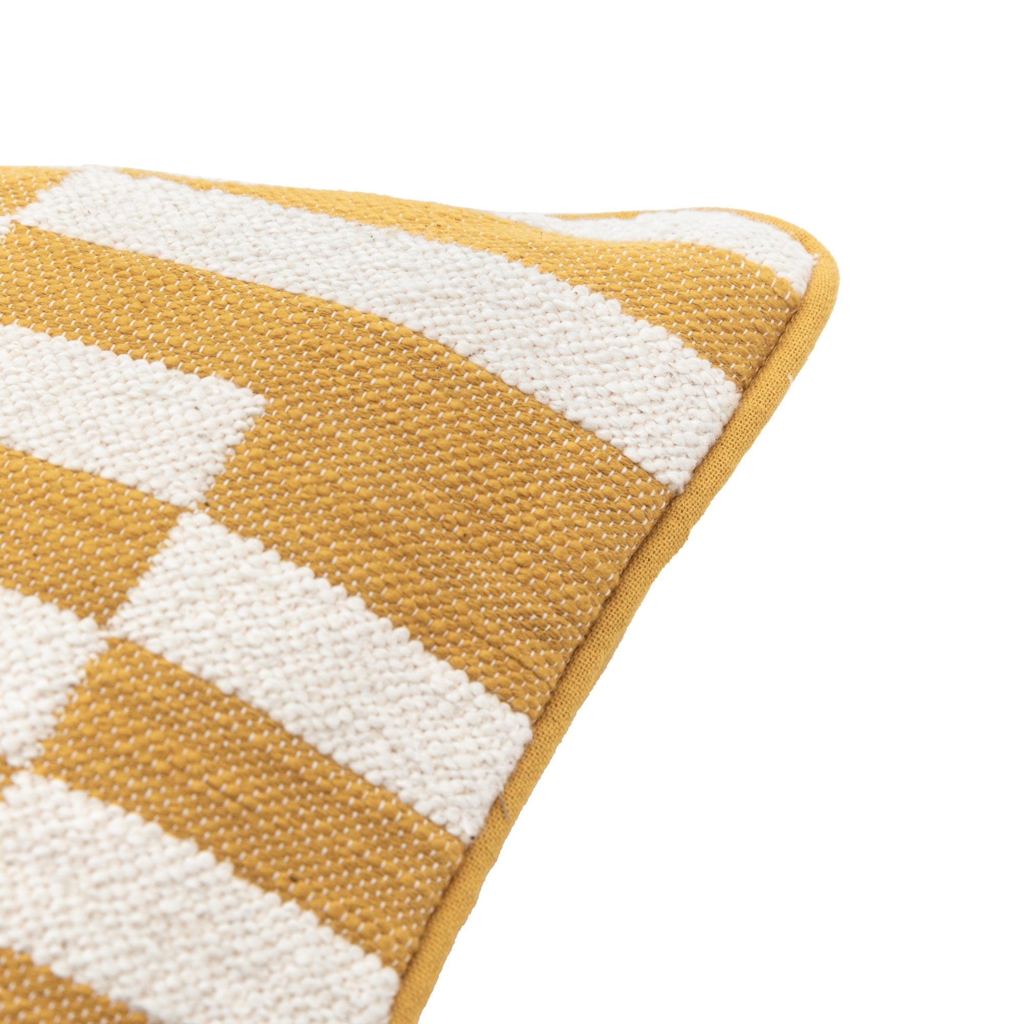 Diagonal close-up of the corner of a yellow and white geometric pattern pillow.