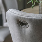 Close-up of the grey fabric upholstered chair's back with a handle cut-out detail.
